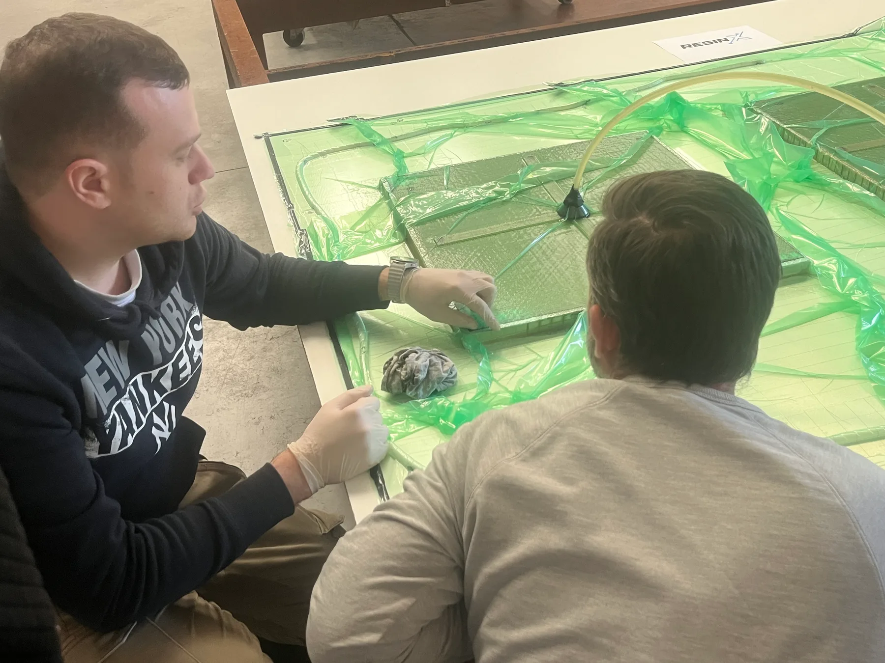 People discussing a composite infusion setup around a worktable
